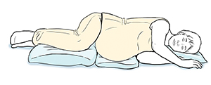 Pregnant woman lying on side with pillows supporting knees, abdomen, and head.
